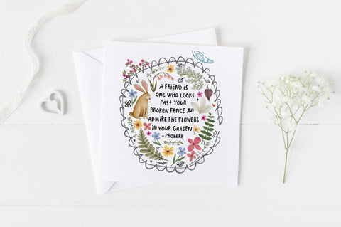 5x5 greeting card by Eliza Todd featuring a garden fence, a rabbit and beautiful flowers, saying "A friend is one who looks past your broken fence to admire the flowers in your garden." - APeaceofWerk.com